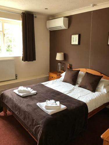 a bedroom with a large bed with two towels on it at The Old Pound Inn in Langport