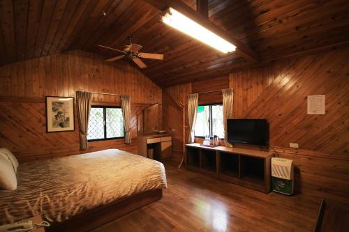 a bedroom with a bed and a flat screen tv at Gemlu in Lugu