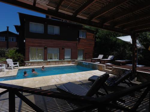 a swimming pool with two people in it at Cabañas Mellmell in Mar de las Pampas