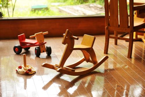 two wooden toy cars sitting on a wooden floor at Hakkei in Maniwa