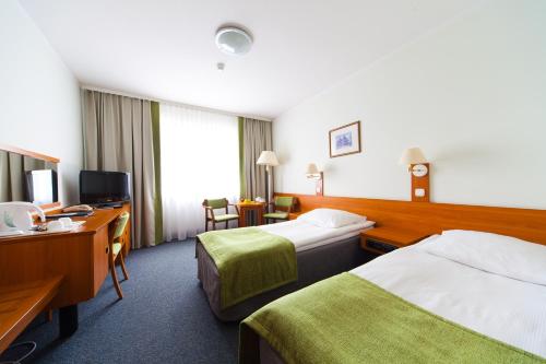 a hotel room with two beds and a desk at Hotel IOR in Poznań