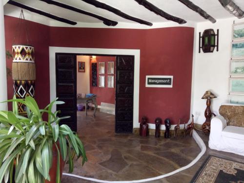 a living room with a red wall at Scorpio Villas Resort in Malindi