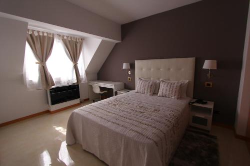 a bedroom with a large bed and a window at Morenos Boutique Hotel in Mindelo