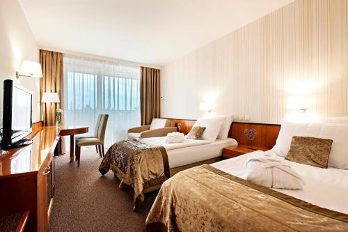 a hotel room with two beds and a couch at Radenci Spa Resort - Sava Hotels & Resorts in Radenci