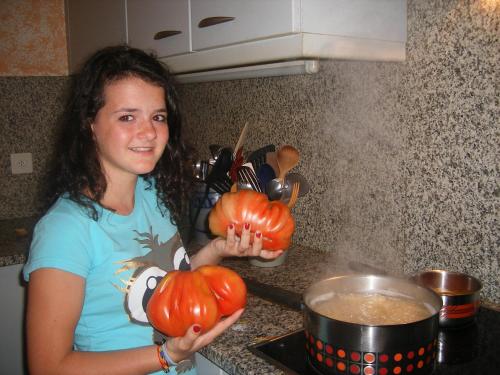 a young woman holding two pumpkins in a kitchen at Da Erminia in Verdabbio