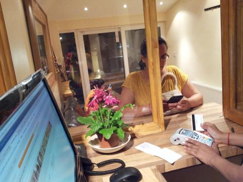 a woman sitting at a table in front of a mirror at The Dharma Lodge in Enfield