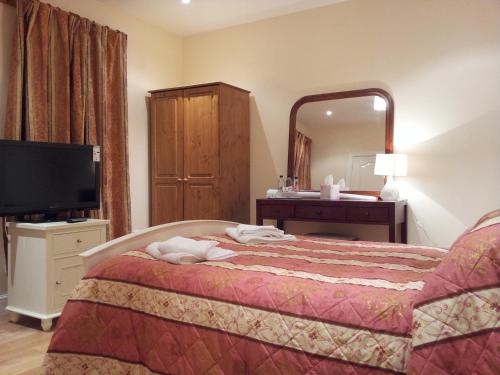 a hotel room with a bed and a mirror at The Dharma Lodge in Enfield