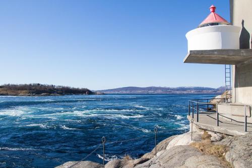 a lighthouse on the side of a body of water at Saltstraumen Hotel in Saltstraumen