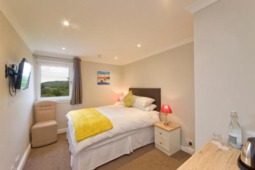 a bedroom with a bed and a window at Falls of Lora Hotel in Oban