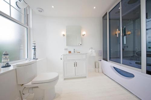 uma casa de banho com um WC, um lavatório e uma banheira em Falls of Lora Hotel em Oban