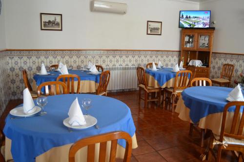 a dining room with blue tables and chairs and a tv at Hotel Marisol in Macedo de Cavaleiros