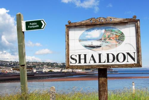 a sign for a saloon next to the water at The Ness in Teignmouth