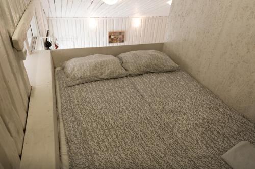 1 cama pequeña con 2 almohadas en una habitación pequeña en Апарт-коттедж Beauty-mini с сауной и зоной барбекю в Выборге на природе, en Víborg
