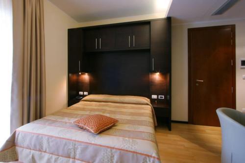 a bedroom with a bed with a pillow on it at Hotel Centro Benessere Gardel in Arta Terme