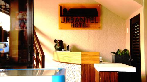 eine Theke in einem Zimmer mit einem Schild an der Wand in der Unterkunft Urbantel Hotel in Lucena