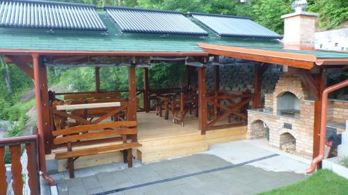 a wooden pavilion with a fireplace and a roof at Vila Silvia in Sovata