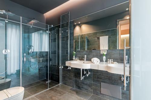 a bathroom with two sinks and a shower at Air Suite Verona in Verona