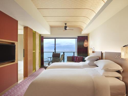 a hotel room with two beds and a view of the ocean at Sheraton Okinawa Sunmarina Resort in Onna