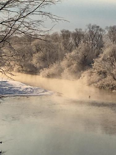 a body of water with mist in the water at Heart'n Tree in Tsurui