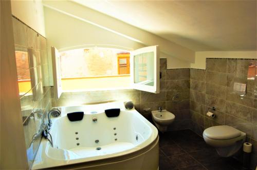 ein Bad mit einer Badewanne und einem WC in der Unterkunft B&B The Tower in Tropea