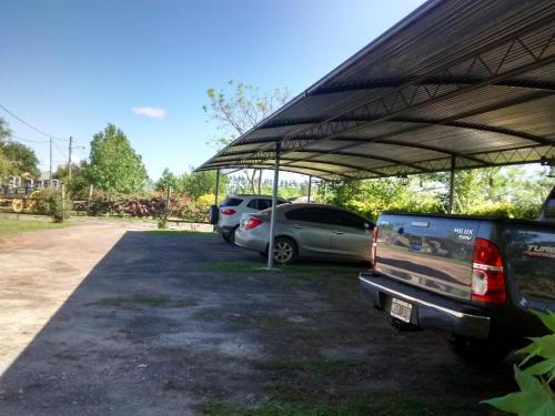 a parking lot with two cars parked under a canopy at Complejo La Colina in Federación