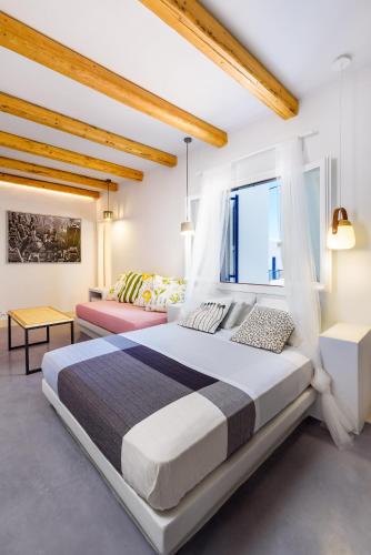 a bedroom with a large bed and a couch at Ios Resort in Ios Chora