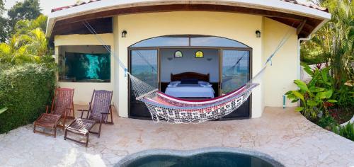a hammock attached to a house with a pool at LagunaVista Villas in Carate