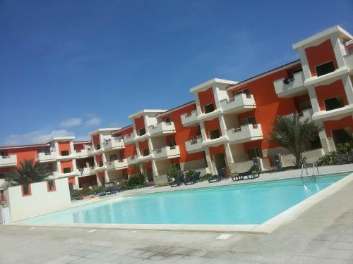 a large apartment building with a large swimming pool at Sal Apartments Djadsal Moradias in Santa Maria