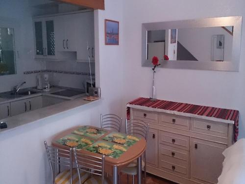 - une cuisine avec une petite table, une table et des chaises dans l'établissement Apartament Tina "Ozonizado", à Playa Flamenca