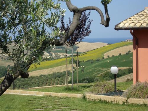 a house with a view of a green field at Agriturismo Il Borgo Degli Ulivi in Roseto degli Abruzzi