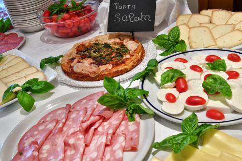 a table topped with different types of meats and cheese at Hotel La Sacca in Stresa