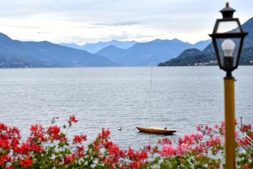 a boat in a body of water with a street light at Hotel La Sacca in Stresa