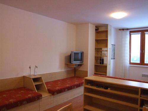 un soggiorno con divano e TV di Apartman Ašek a Ramzová