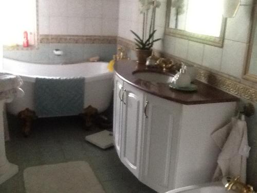 a bathroom with a tub and a sink and a bath tub at Fornuddens Bed and Breakfast in Tyresö