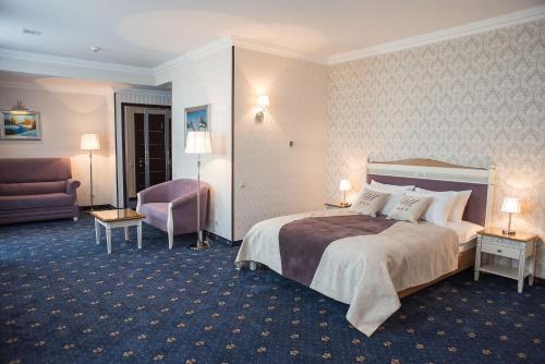 una habitación de hotel con una cama y una silla en Shato Hotel ШАТО, en Chervonograd