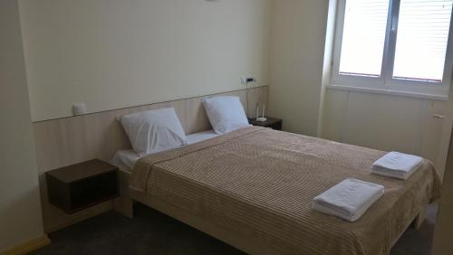 a bedroom with a bed with two towels on it at Apartments Mavesa in Vrnjačka Banja