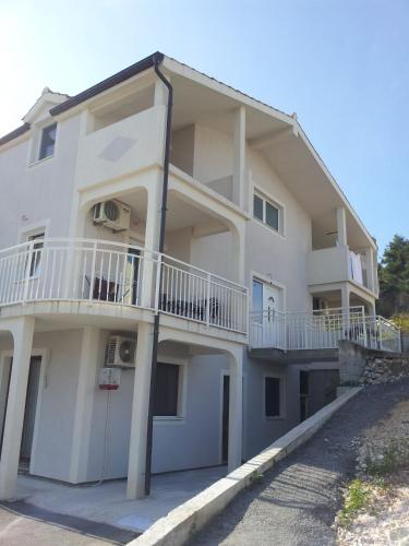 a white building with balconies on the side of it at Apartments Holiday Gavric in Trogir