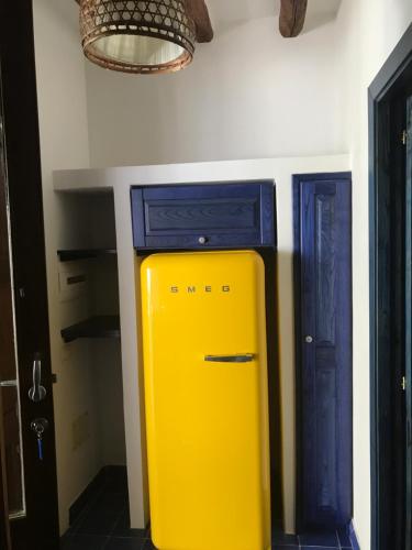 żółtą lodówkę w pokoju z niebieskimi drzwiami w obiekcie Casa Martha w mieście Stromboli