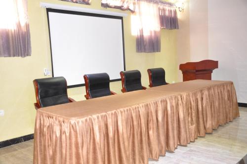 a long table with chairs in a room with a screen at Tigers's apartment Hotel in Bujumbura