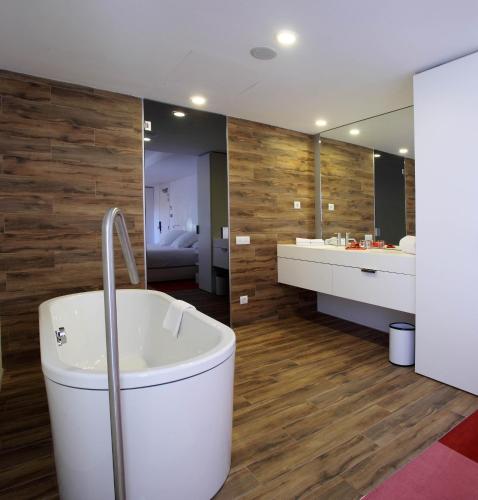 a bathroom with a tub and a large mirror at Room Mate Pau, Barcelona in Barcelona