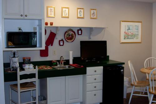 eine Küche mit einer Theke mit einer Spüle und einem TV in der Unterkunft Mount Battie Inn in Lincolnville