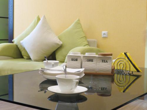 a living room with a couch and a table with dishes on it at Your Home Hotel in Tbilisi City
