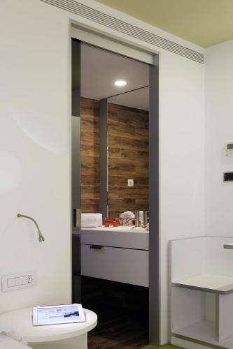 a bathroom with a toilet and a mirror at Room Mate Pau, Barcelona in Barcelona