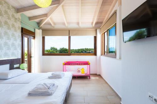 - 2 lits dans une chambre avec 2 fenêtres dans l'établissement Kampos Villas, pure elegance, By ThinkVilla, à Achlades
