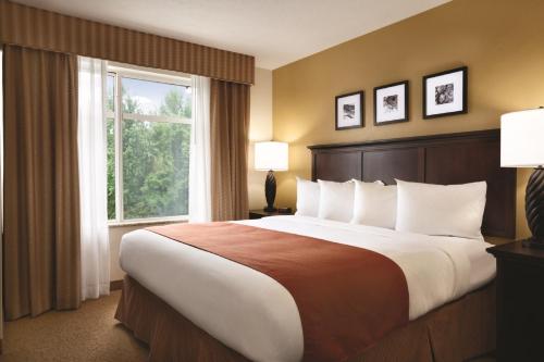 a large bed in a hotel room with a window at Country Inn & Suites by Radisson, Pineville, LA in Pineville