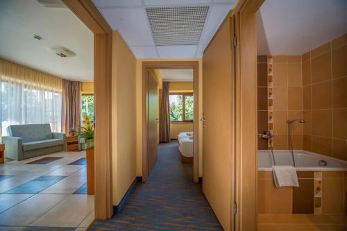 ein Badezimmer mit einer Badewanne, einem WC und einem Waschbecken in der Unterkunft Duna Hotel in Paks