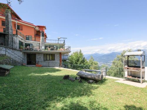 a house with a yard with a view of the mountains at Hotel Funivia in Laveno-Mombello