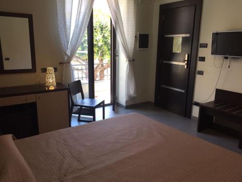 a bedroom with a bed and a door to a balcony at B&B Iacolà in Bacoli