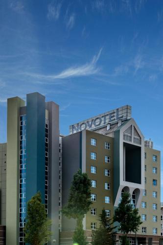 a building with a sign on top of it at Novotel Firenze Nord Aeroporto in Sesto Fiorentino