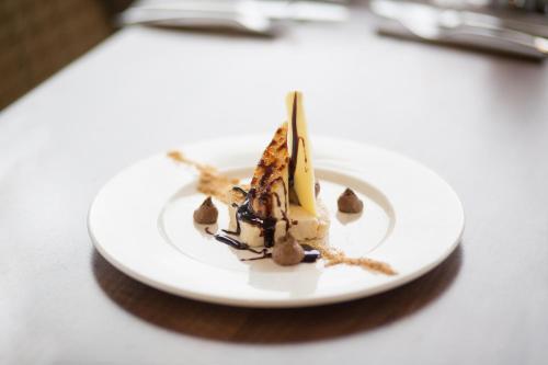 a white plate with a dessert on a table at Angels Hotel in Uddingston